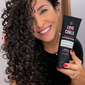 Woman holding a bottle of 'Love ur Curls' product with styled hair